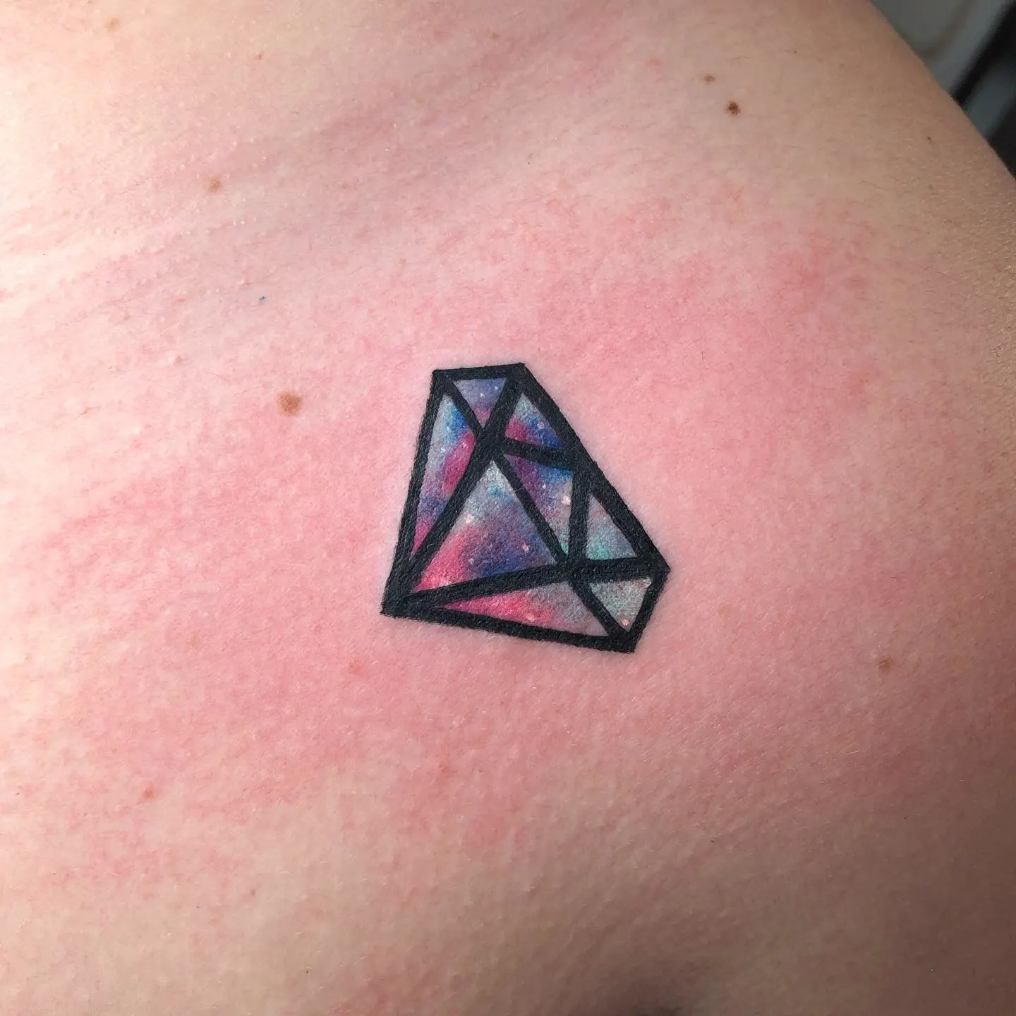 Tatuaje geométrico de Bowser reinterpretado con formas angulares y color en la pantorrilla
